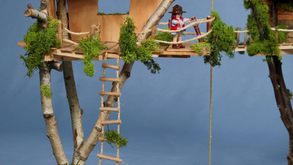 Auf dem Bild ist ein kleines Baumhaus zu sehen mit einer Playmobilfigur.